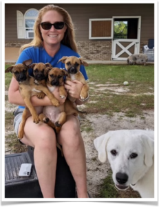 Sabrina Byrum with her foster pups and adopted dog, Allie, who helps keep the little ones entertained.